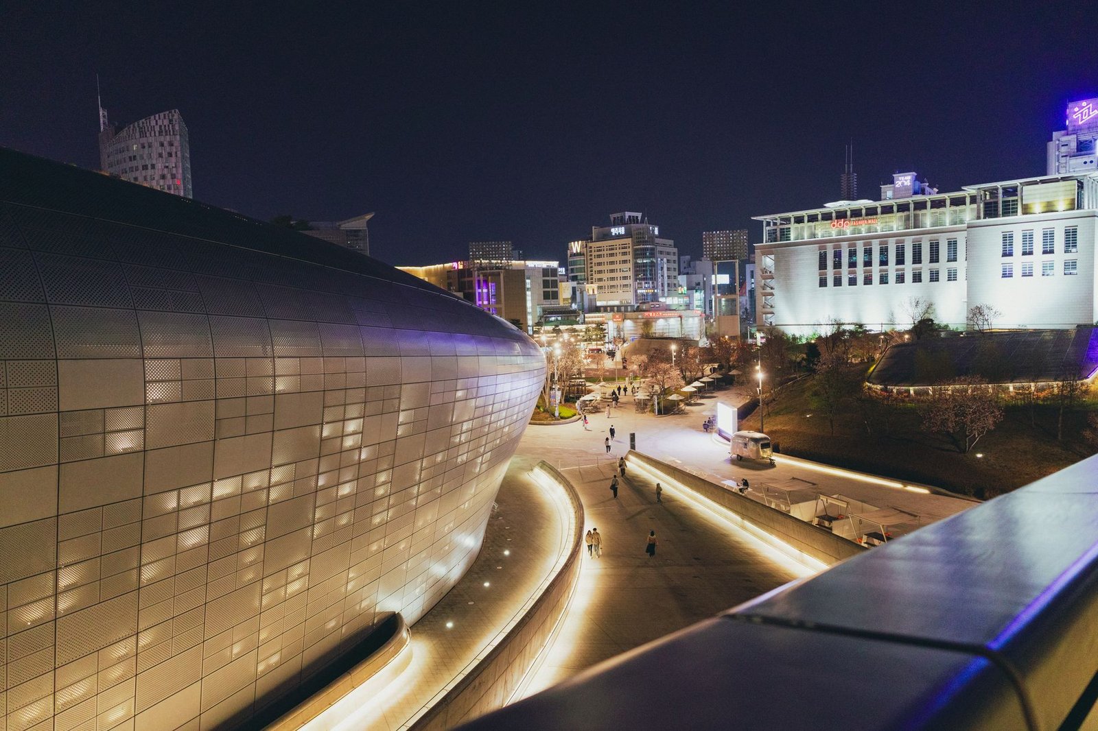 A stunning night shot of Dongdaemun Design Plaza in Seoul with illuminated cityscape