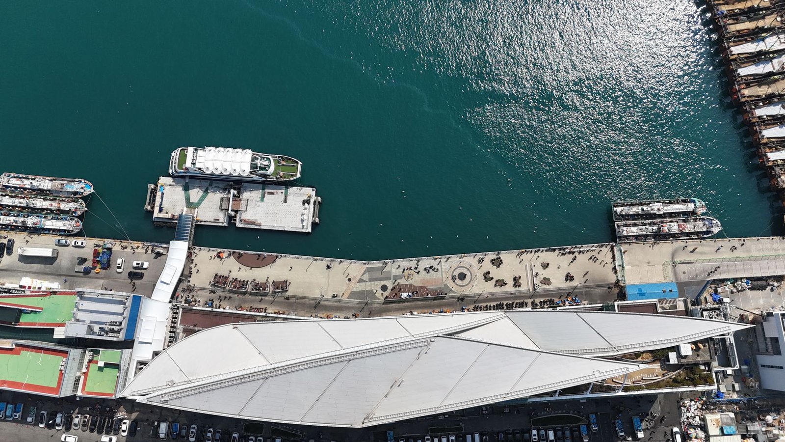 Aerial shot of Busan port showcasing ships at the pier and bustling urban activity