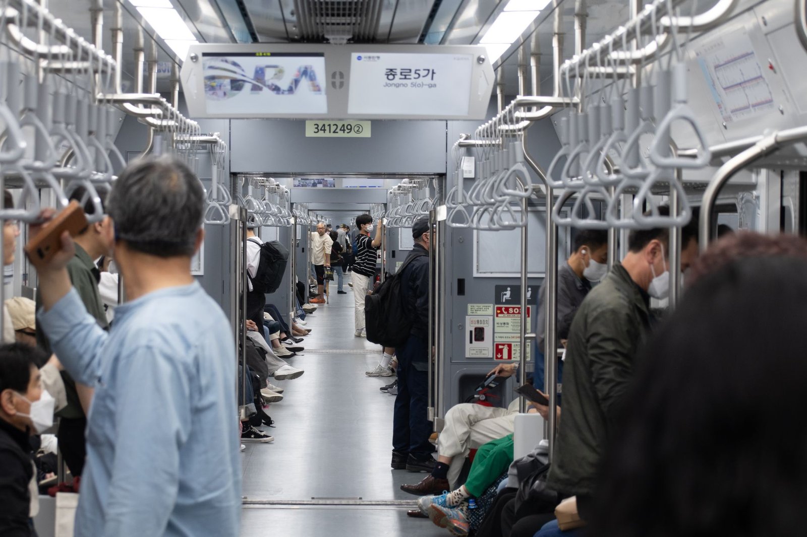 A busy subway scene in Seoul with diverse commuters. Interior view showing daily urban life