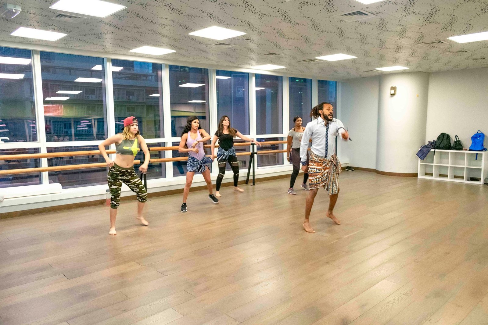 Vibrant dance class session led by an instructor in a modern studio with diverse participants