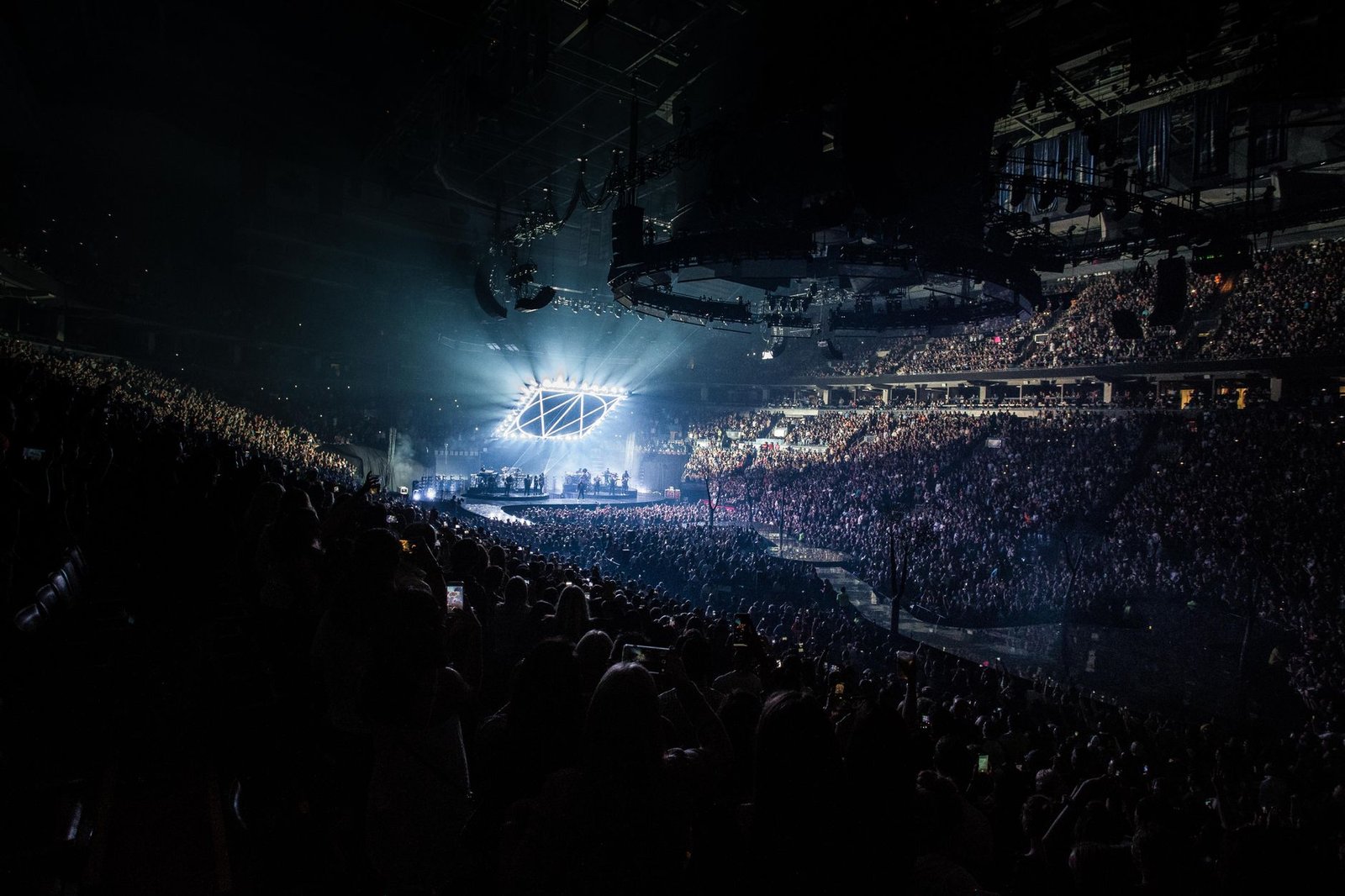 Energetic concert scene featuring a packed audience, vibrant lights, and a live performance on stage