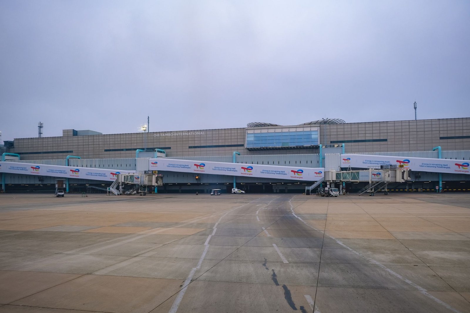 View of a modern airport terminal with jet bridges leading to the runway