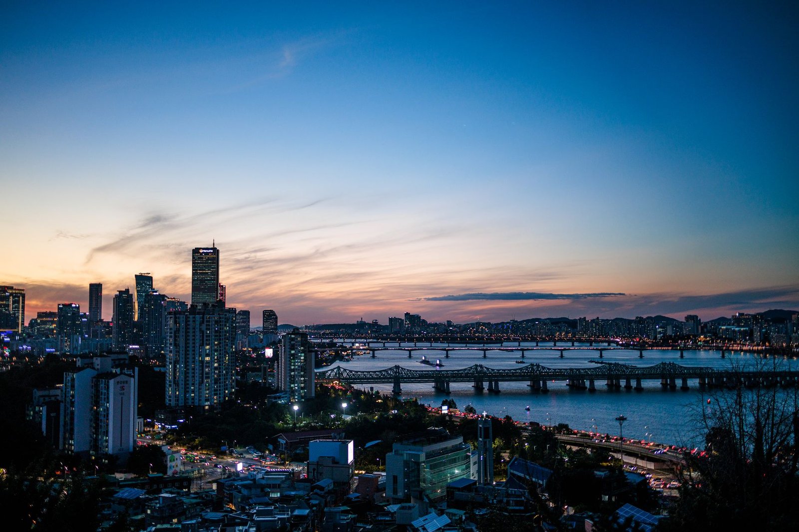 Explore the vibrant skyline of Seoul at twilight, featuring iconic buildings and the Han River