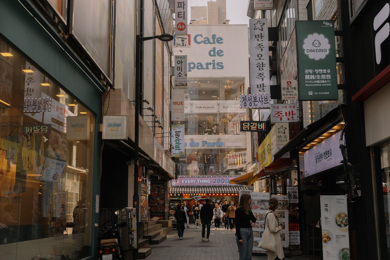 Bustling urban street in Myeongdong, Seoul showcasing diverse shops and lively pedestrian activity