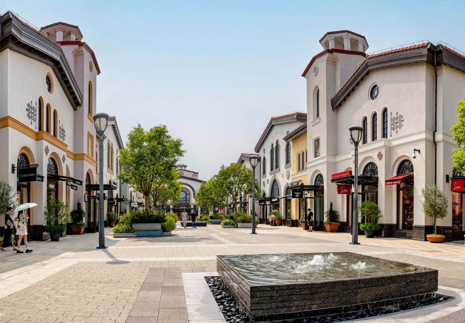 Elegant shopping arcade in Noventa di Piave, Italy bustling with tourists under a sunny sky