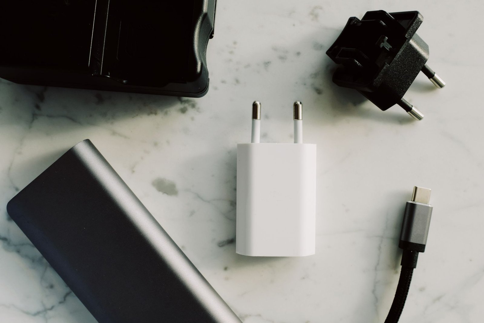 A collection of electronic adapters and chargers featuring USB-C and other connectors on a marble surface