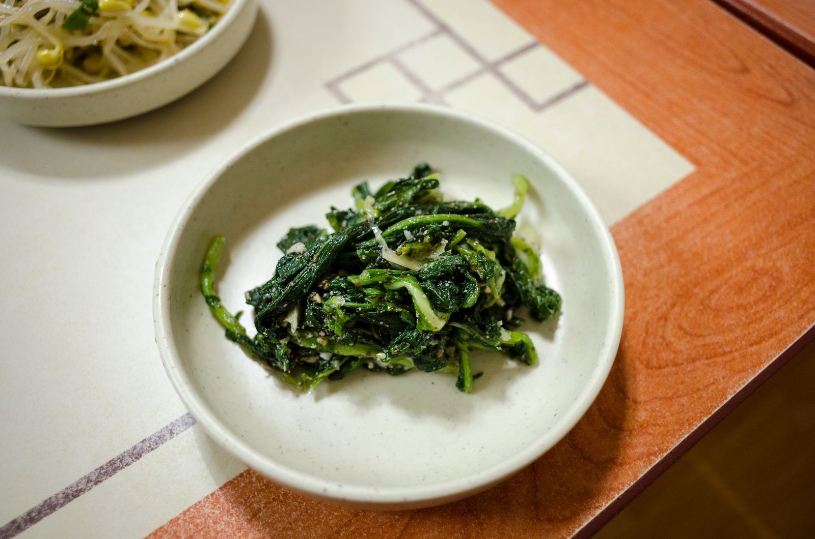 Tasty Asian spinach dish served in a white bowl, ideal for healthy dining Tasty Asian spinach dish served in a white bowl, ideal for healthy dining